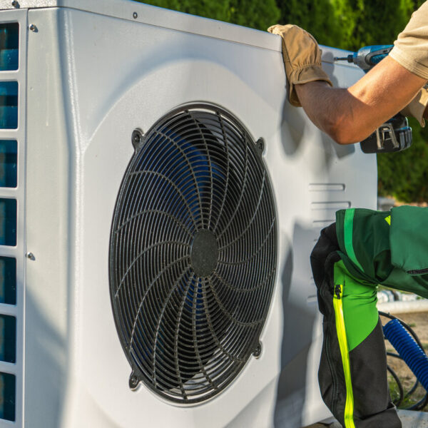 HVAC worker installing electric heat pump near me